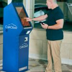 Home Man interacting with CoinCloud ATM kiosk indoors for cryptocurrency transactions.